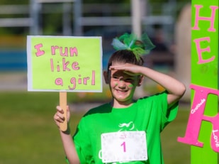 Girls on the Run participant holding "I run like a girl" sign