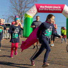 Girls on the Run participants with cape finishing 5K