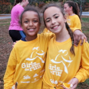 2 girls in yellow shirts smile after practice 5K with team